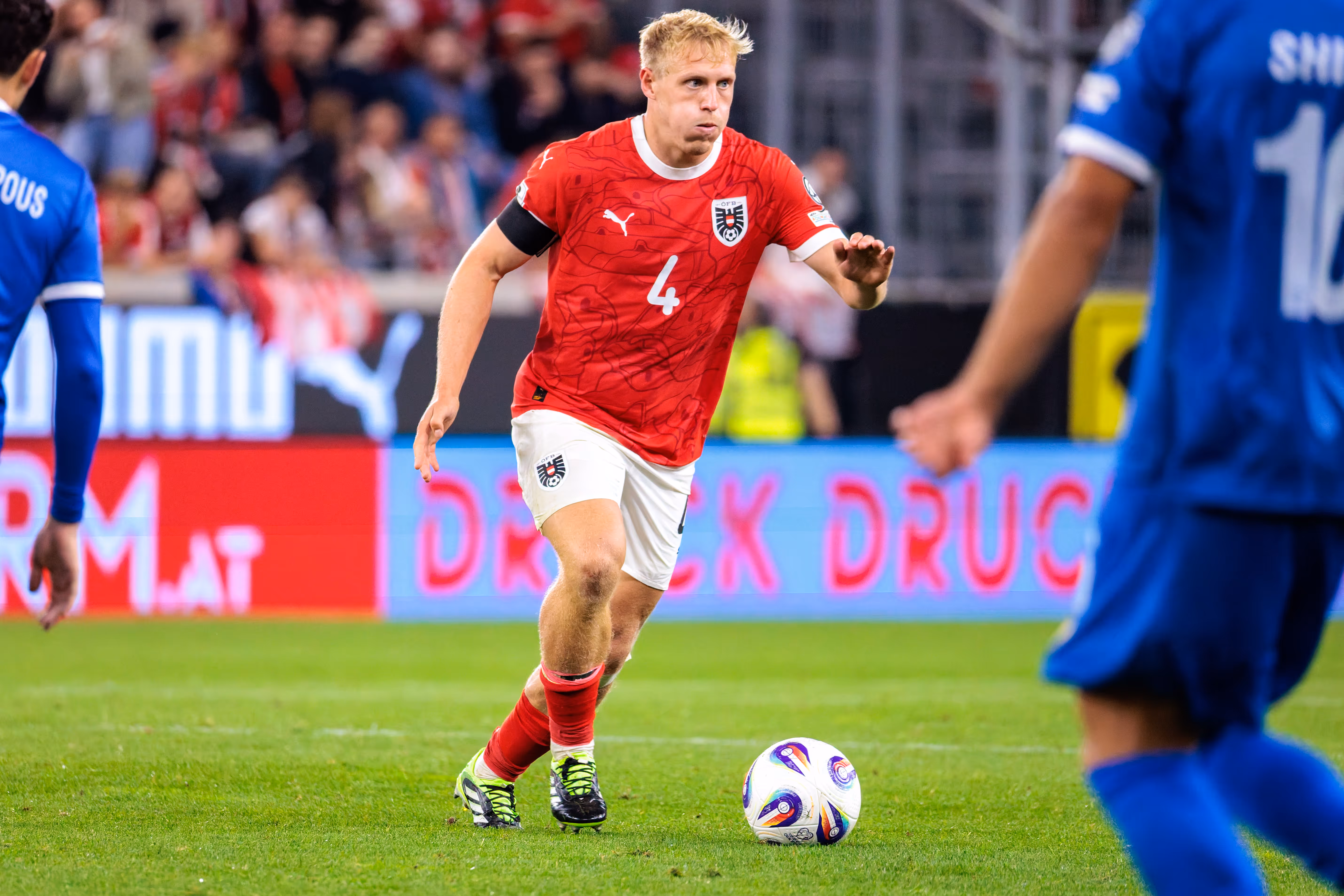 Xaver Schlager im roten Trikot der österreichischen Nationalmannschaft mit der Nummer 4 dribbelt konzentriert den Ball im Spiel gegen Zypern